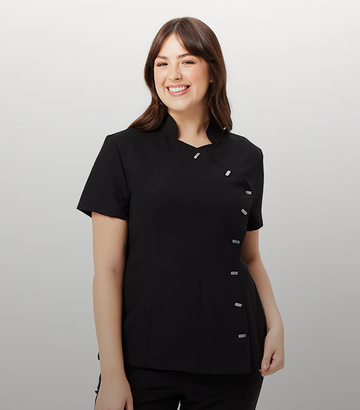 Woman wearing a black scrub top with buttons on a white background